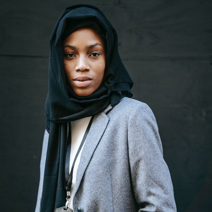 black woman in hijab standing near wall