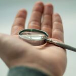 male hand holding a magnifying glass